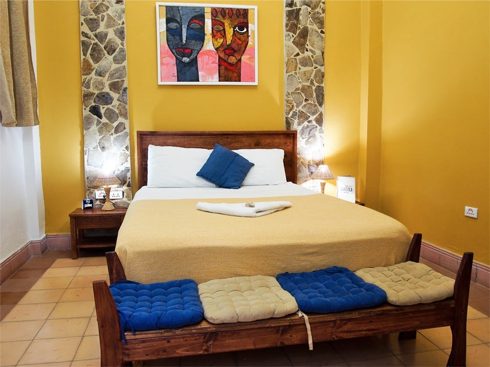 The queen size bed in the Yellow room in La Gargola guesthouse in Old Havana, Cuba